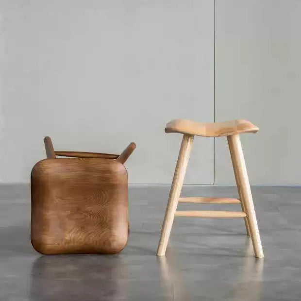 Minimalist Wabi-sabi solid ash wood stool with cylindrical legs for modern home and hotel decor.